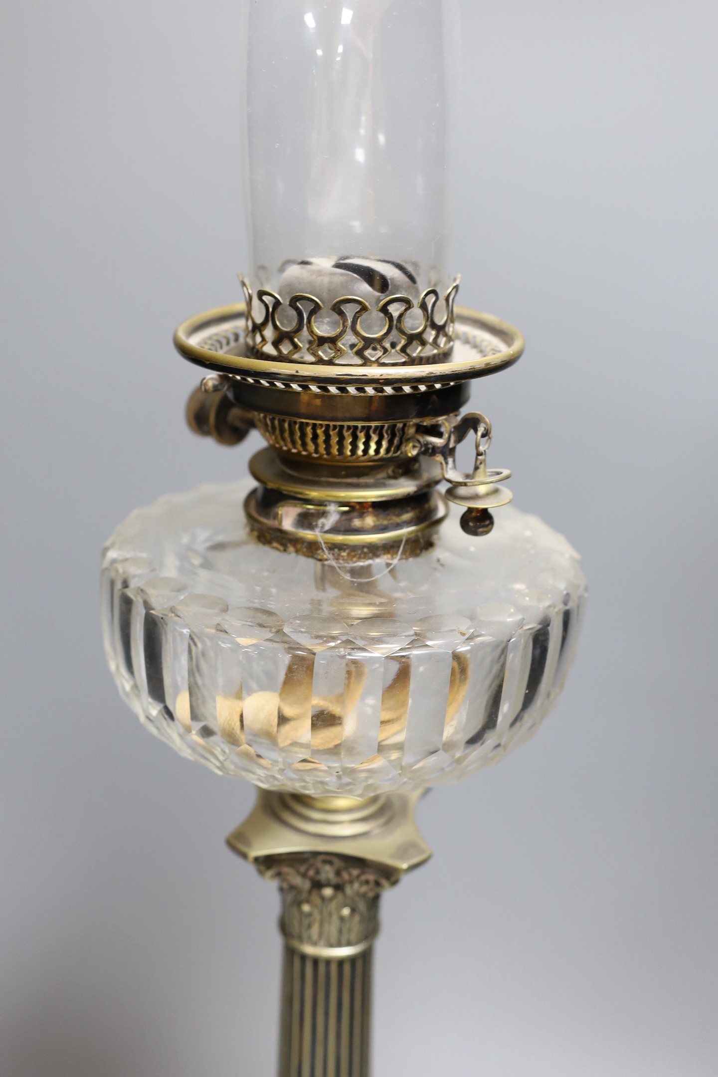 A Victorian silver plated Corinthian column oil lamp, with a glass reservoir